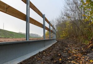 Eine Stahl-Amphibienleitwand schützt an der Rastanlage Hochmoor Kröten und andere Kleintiere im angrenzenden Waldstück beim Überqueren der Straße. 